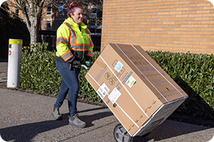 Worker moving a box with a dolly